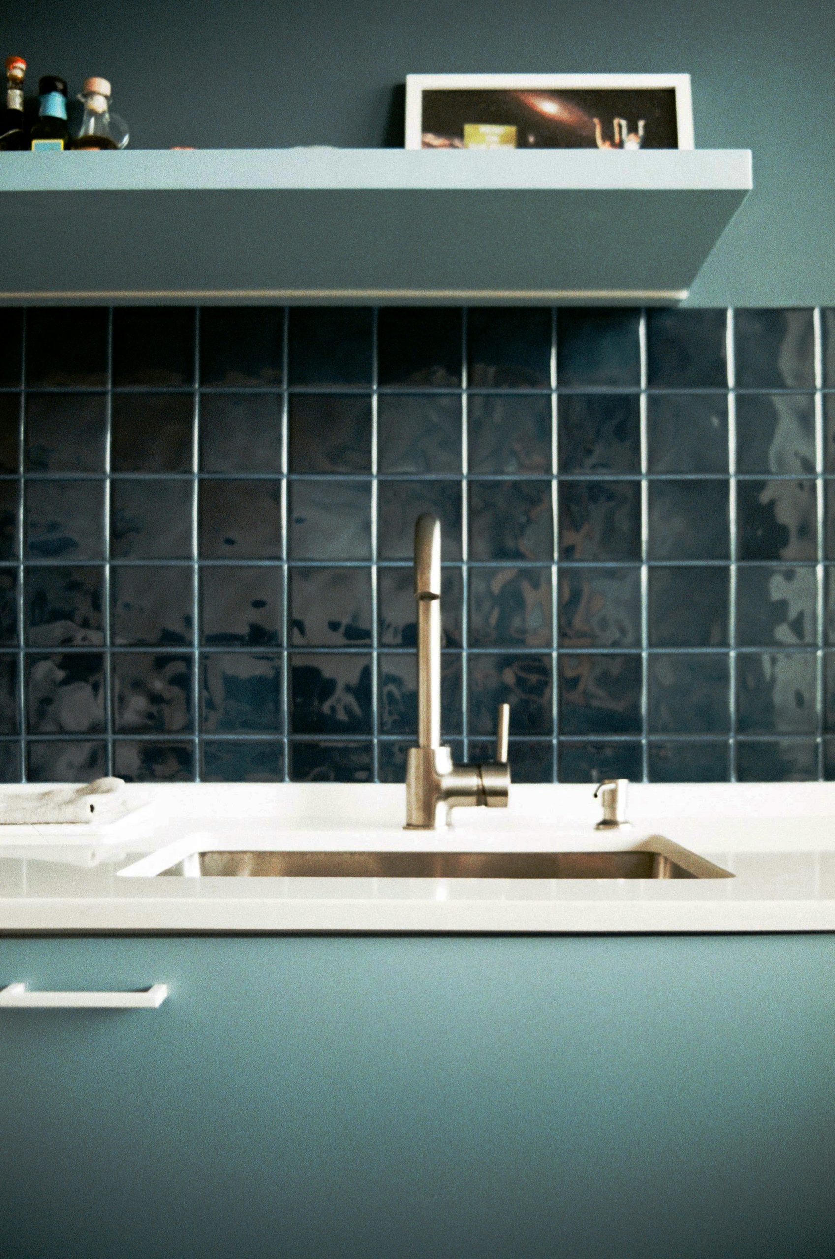 Close-up of a modern faucet installation with elegant tiling work behind it