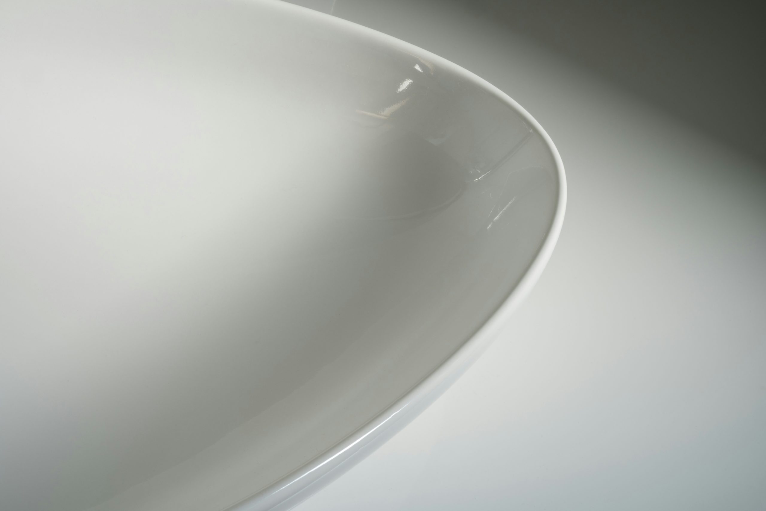 Close-up of a high-quality silicone joint application on a white ceramic sink ensuring perfect waterproofing