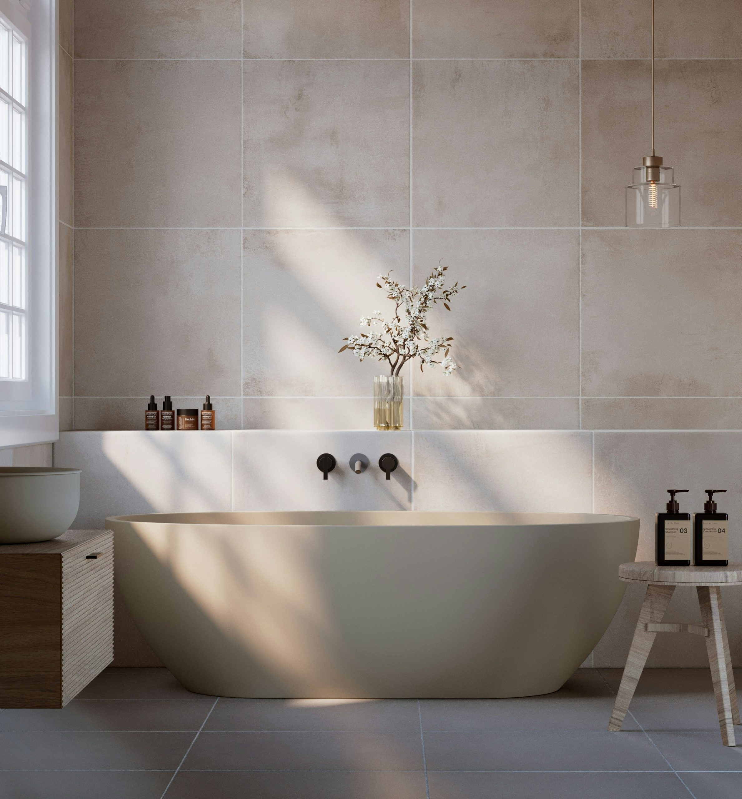 Beautiful clean bathroom with beige ceramic tiles and a freestanding bathtub during daylight.