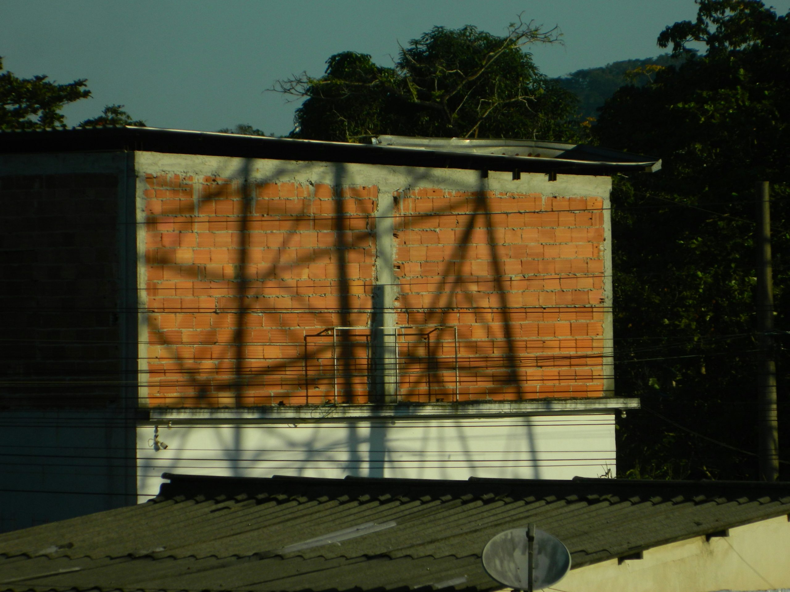 Gros plan sur la pose de carrelage mural, montrant les croisillons et le niveau laser pour une précision parfaite