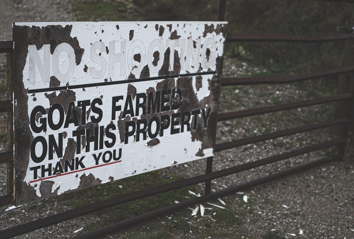 A sign on a fence that says goats farmers on this property thank you