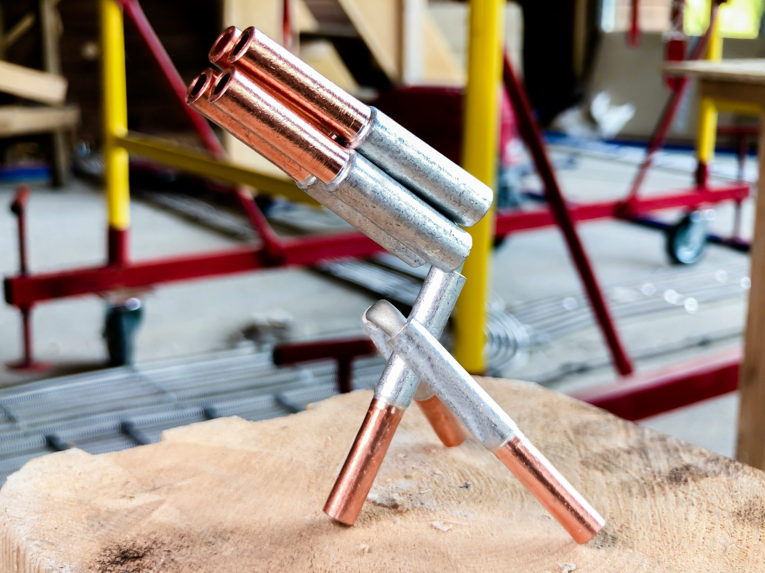 Gros plan sur des tuyaux en cuivre neufs et brillants avec des outils de plomberie professionnels en arrière-plan