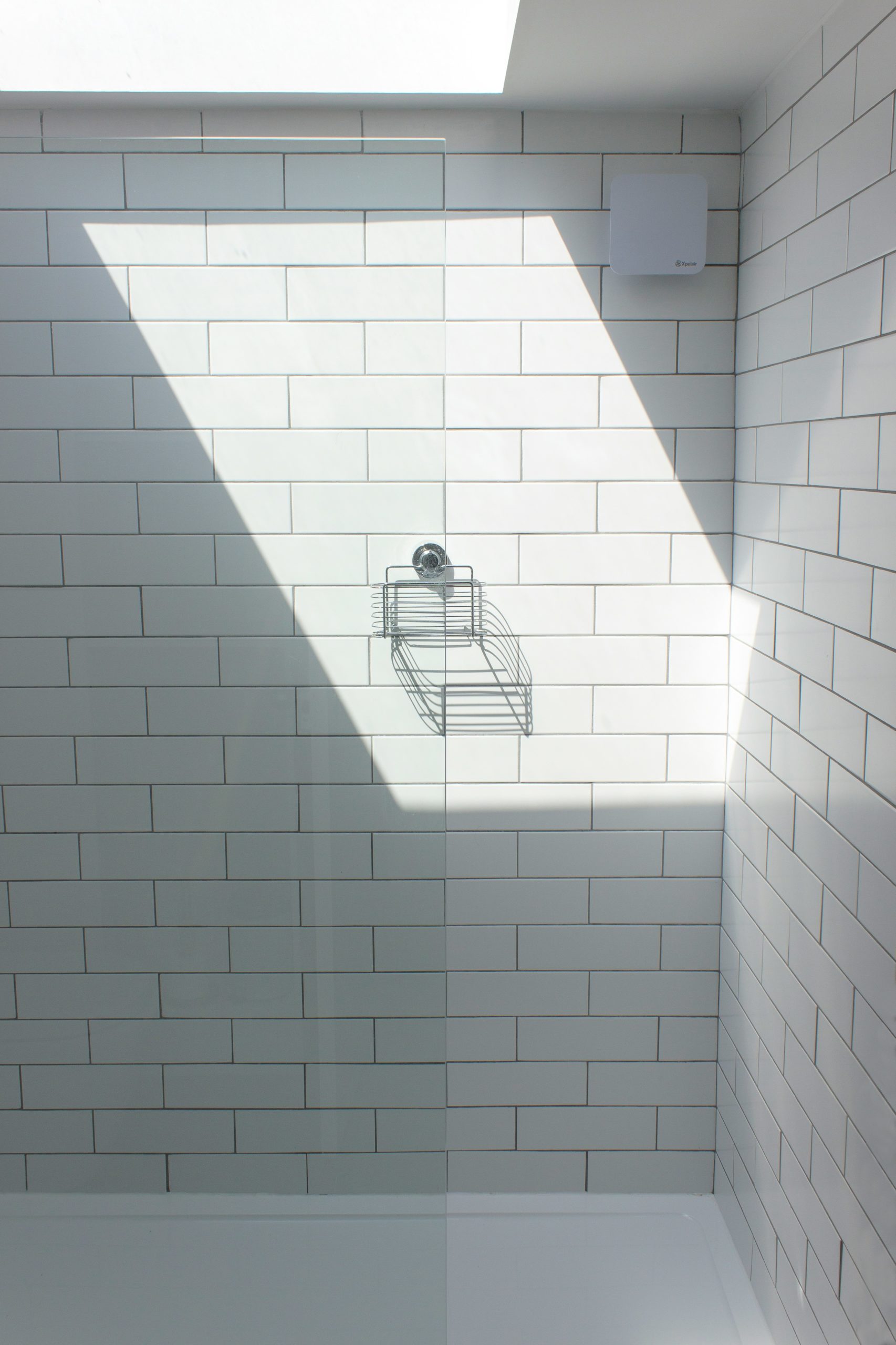 Une salle de bain minimaliste et sereine avec des carreaux blancs et des accessoires chromés, évoquant la paix intérieure après une journée bien remplie.