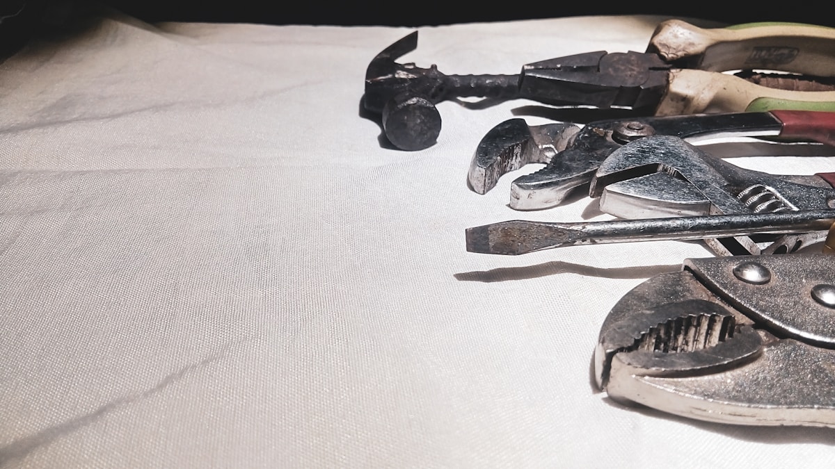 Outils de réparation et de construction en métal sur fond blanc.