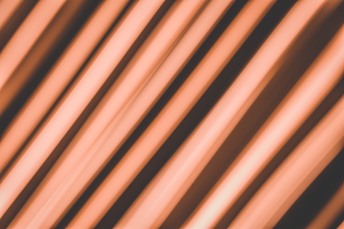 Motifs diagonaux orange et noirs abstraits.