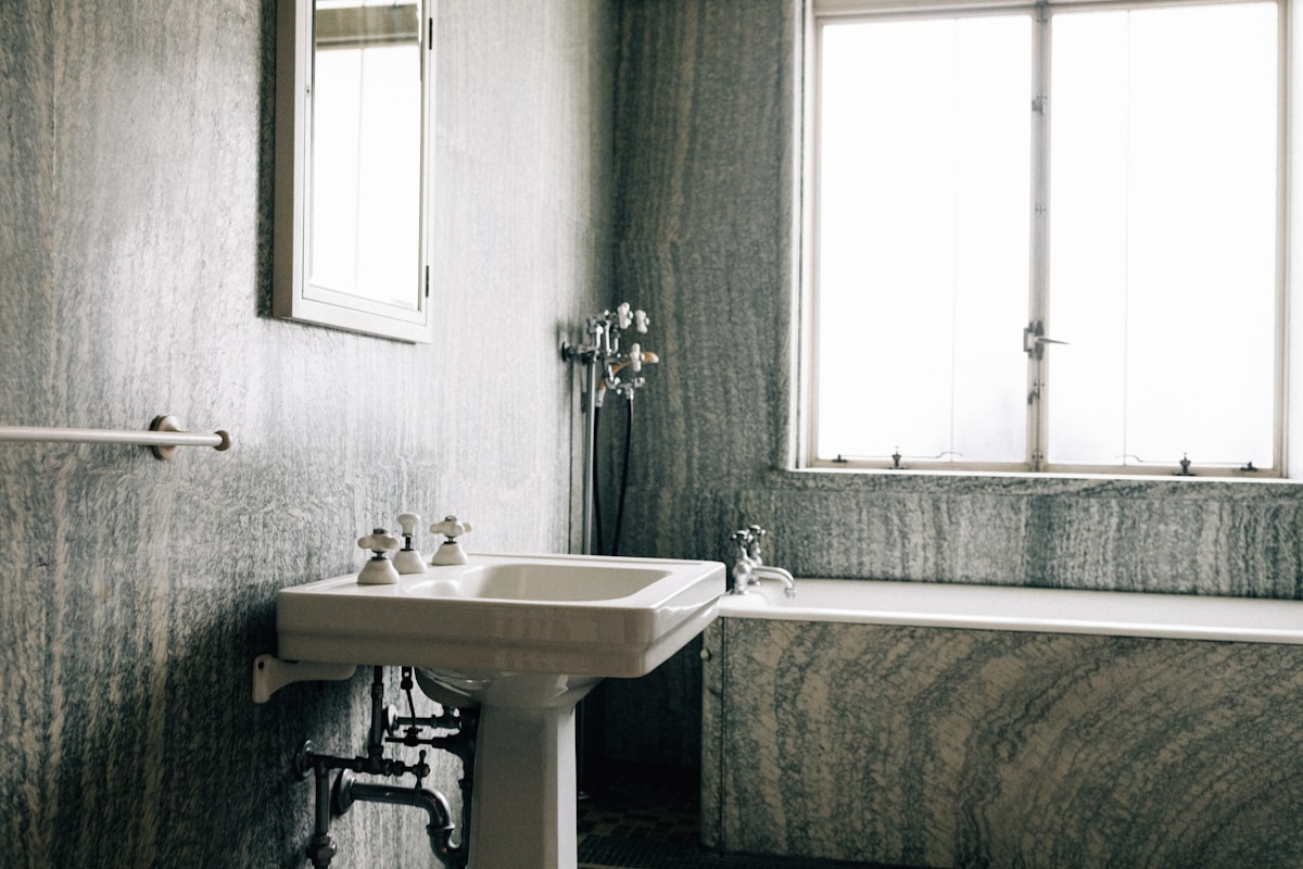 Salle de bain vintage avec lavabo et fenêtre.
