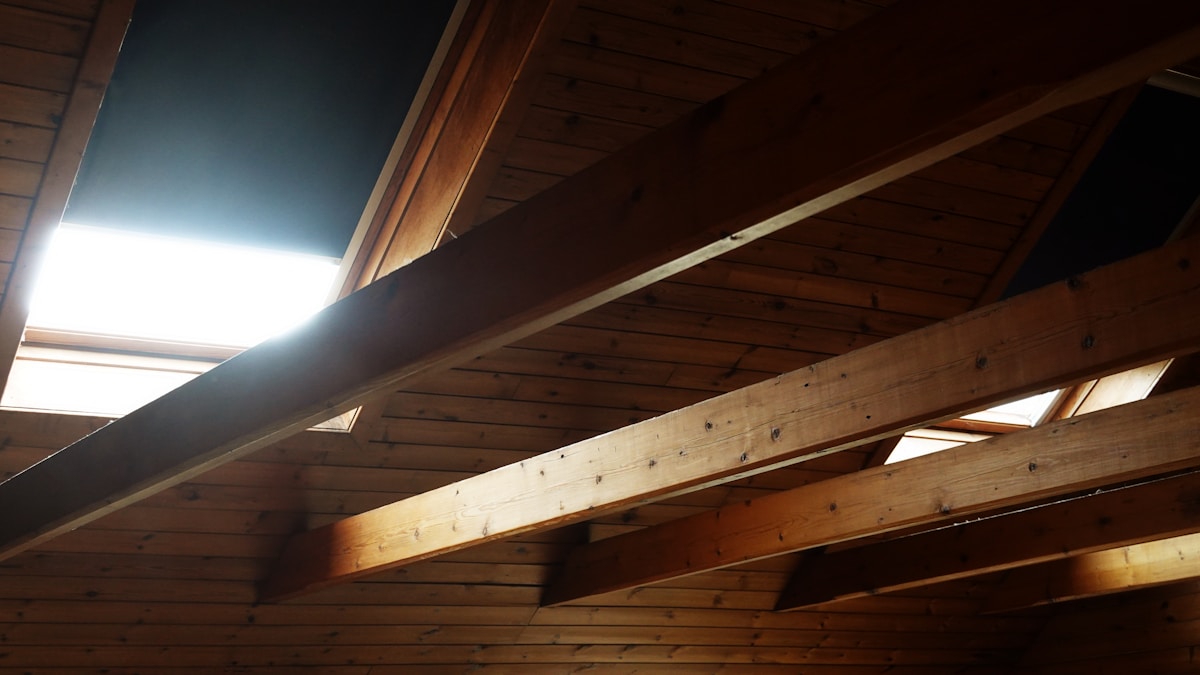 Intérieur d'un toit en bois avec poutres apparentes.