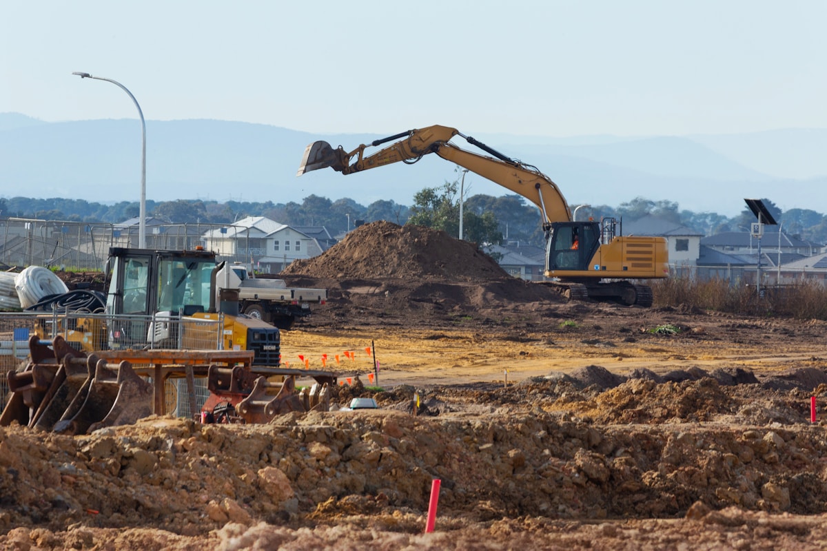 Chantier de construction avec excavatrice et camion de terrassement.