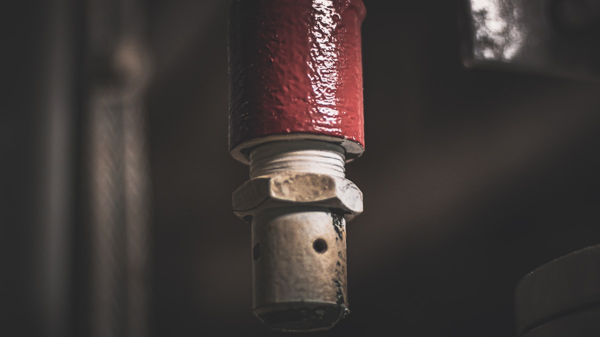 Tuyau de métal rouge brillant avec écrou en métal.