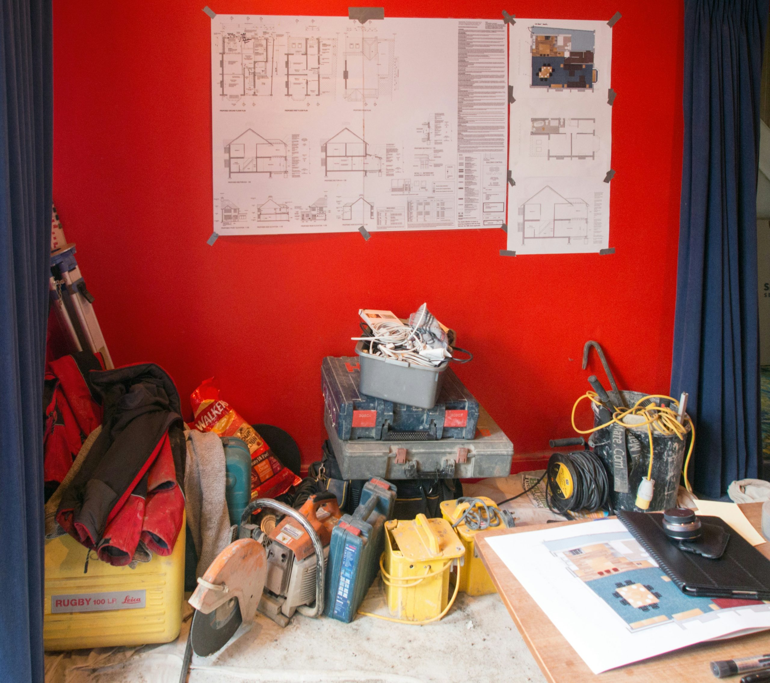 Plans de construction et outils de plomberie sur une table.