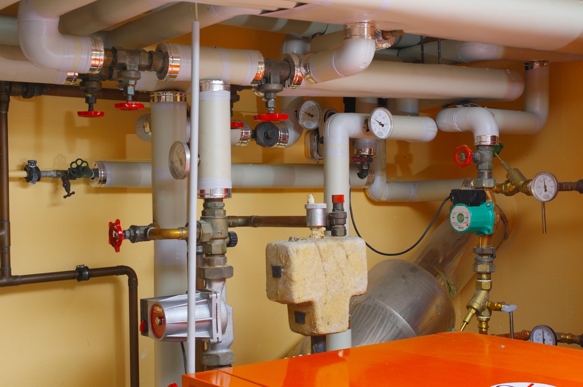 Tuyaux, jauges et équipements techniques dans une salle des machines.
