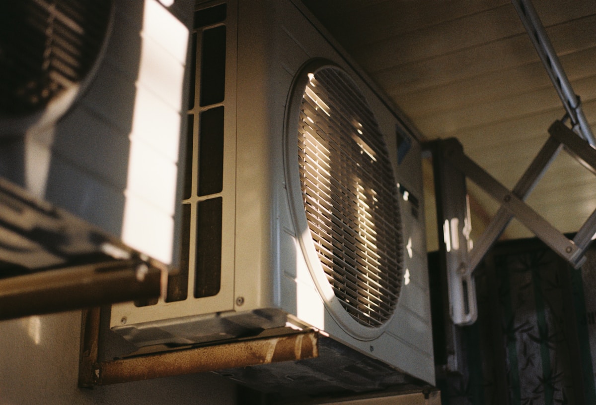 Unité de climatisation murale avec grille d'aération sombre.