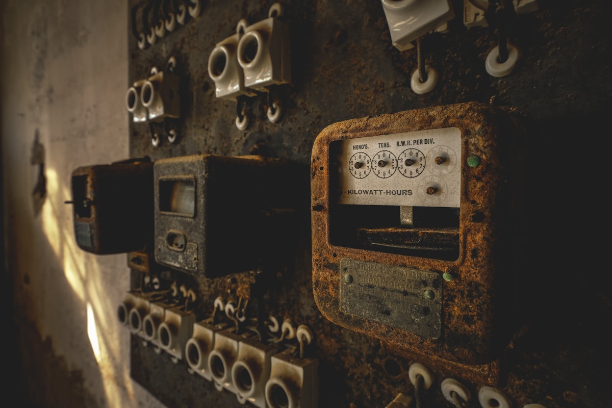 Compteur électrique vintage rouillé dans un endroit sombre et délabré.
