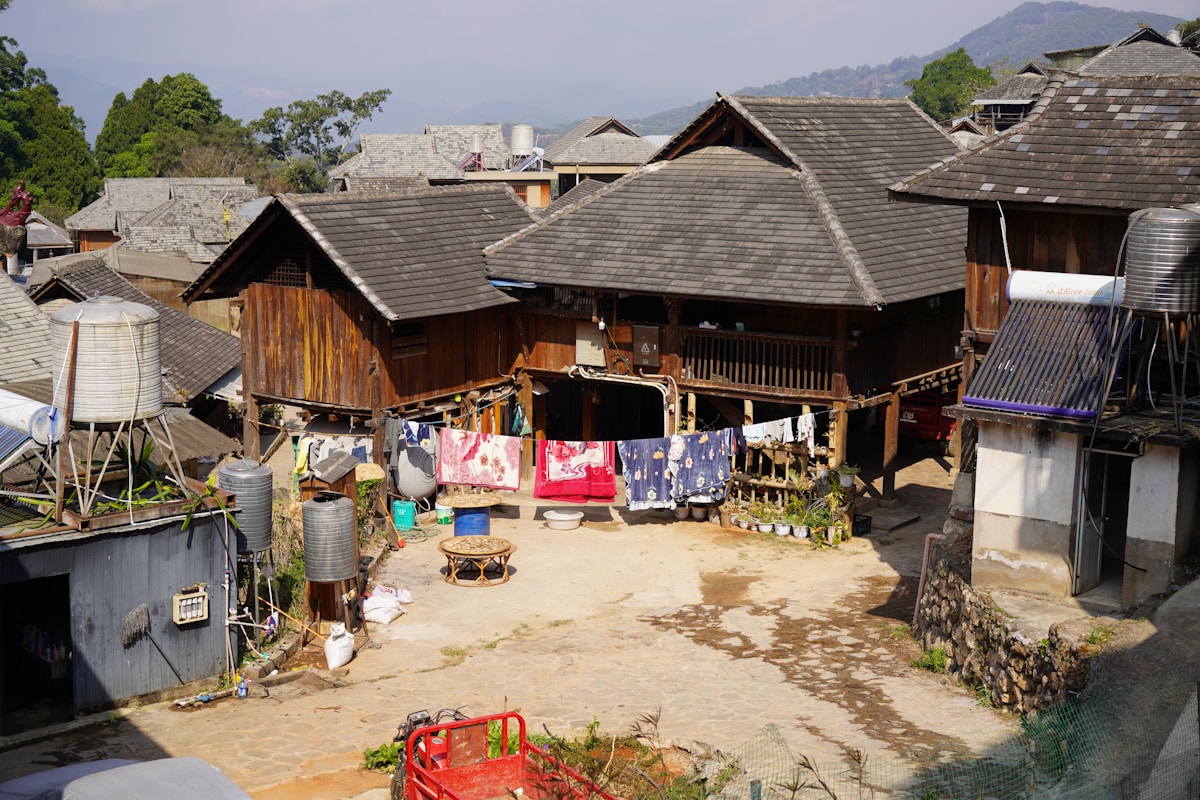 Village de maisons en bois avec toits en tuiles, étendage de linge coloré.