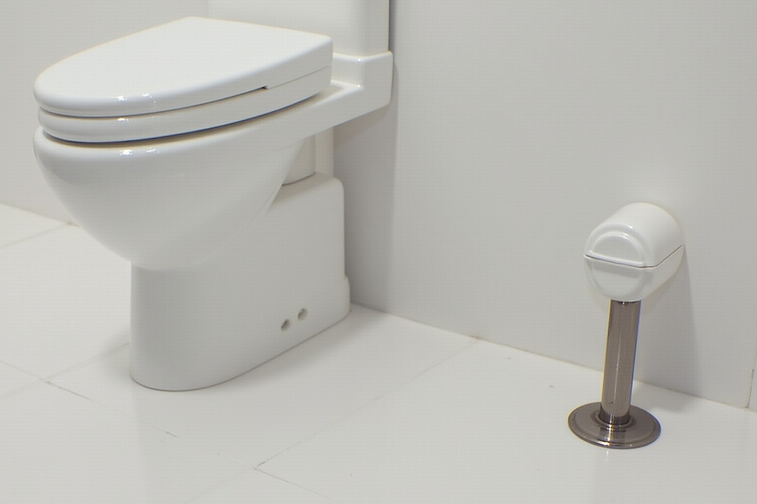 Toilette blanche moderne avec accessoire de salle de bain.