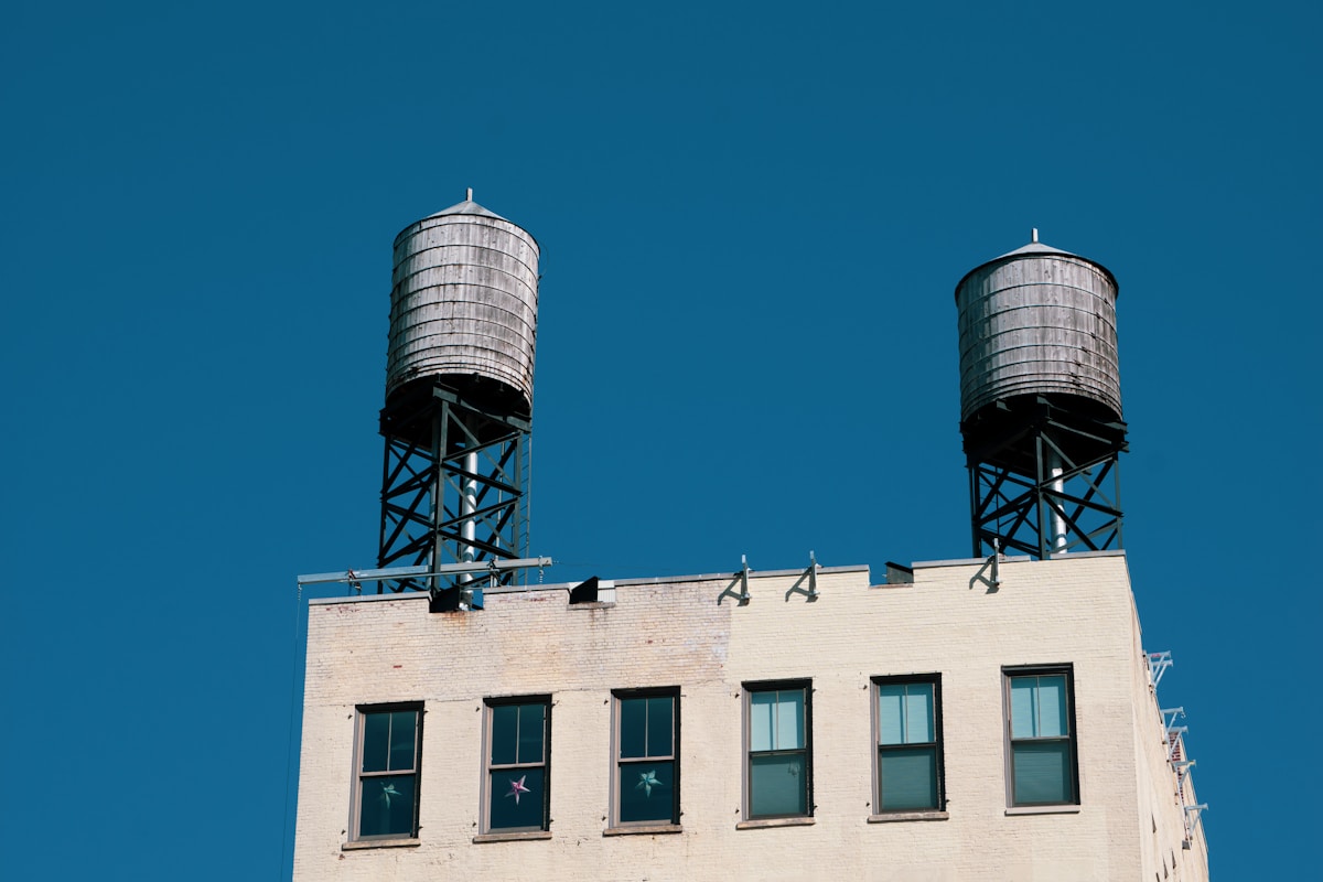Deux tours d'eau en acier sur un bâtiment industriel.