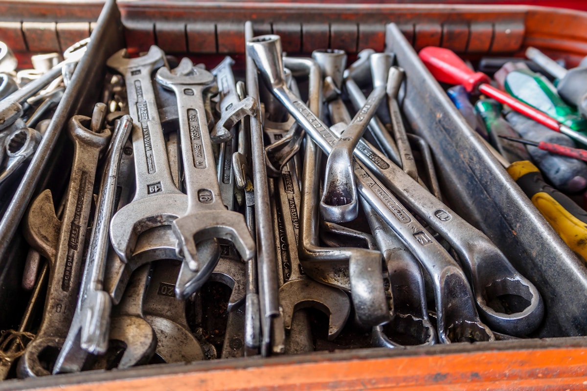 Boîte à outils remplie d'outils de réparation variés et usagés.