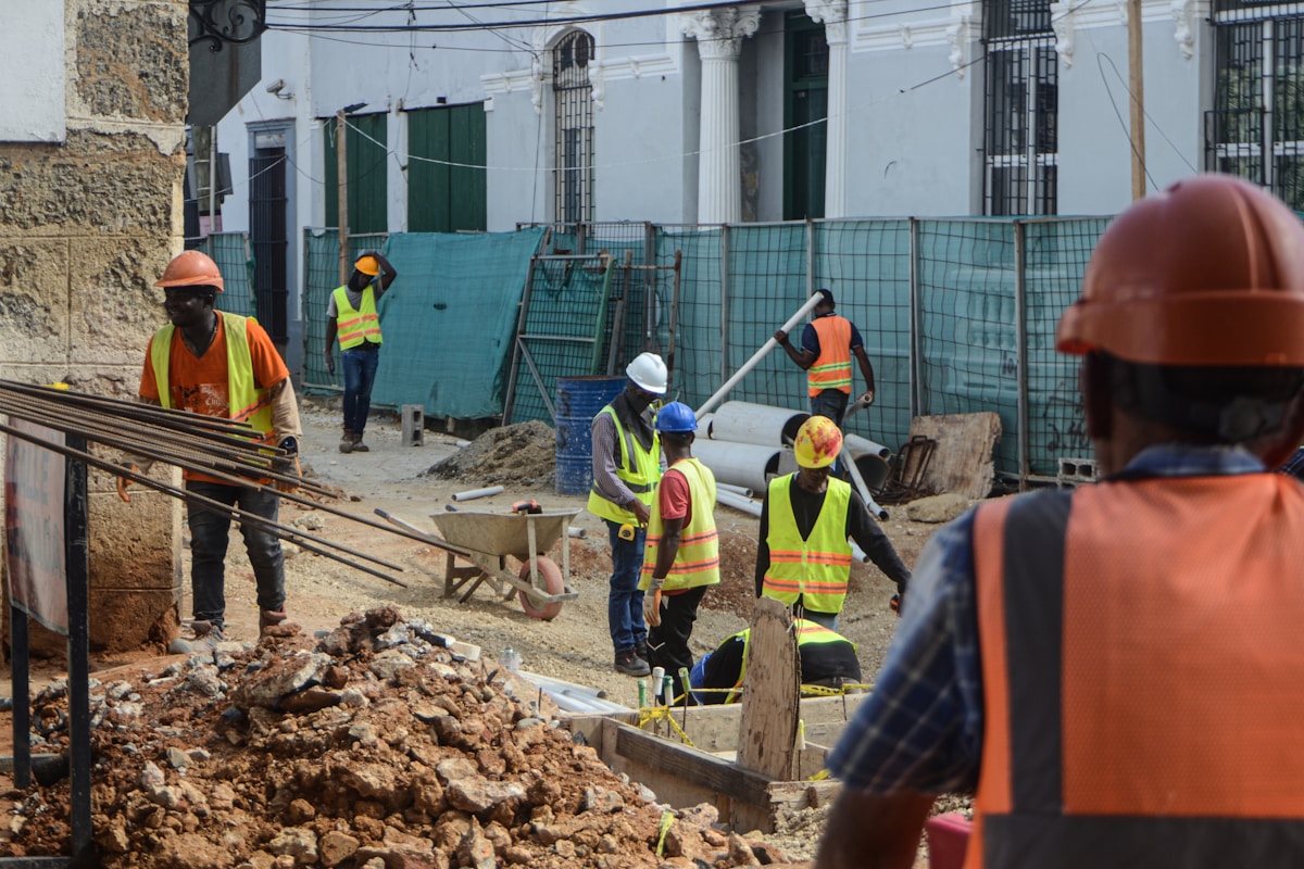 Chantier de construction avec des travailleurs en uniforme de sécurité.
