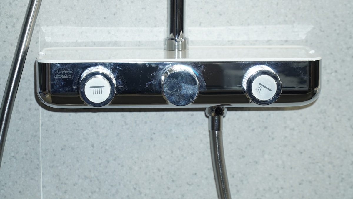 Robinet de douche avec boutons de contrôle en métal chromé.