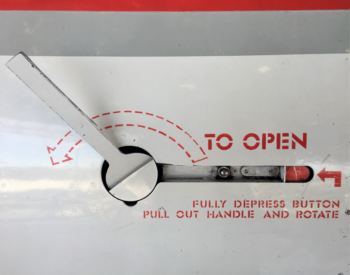 Mécanisme d'ouverture avec instructions d'utilisation en rouge et blanc.