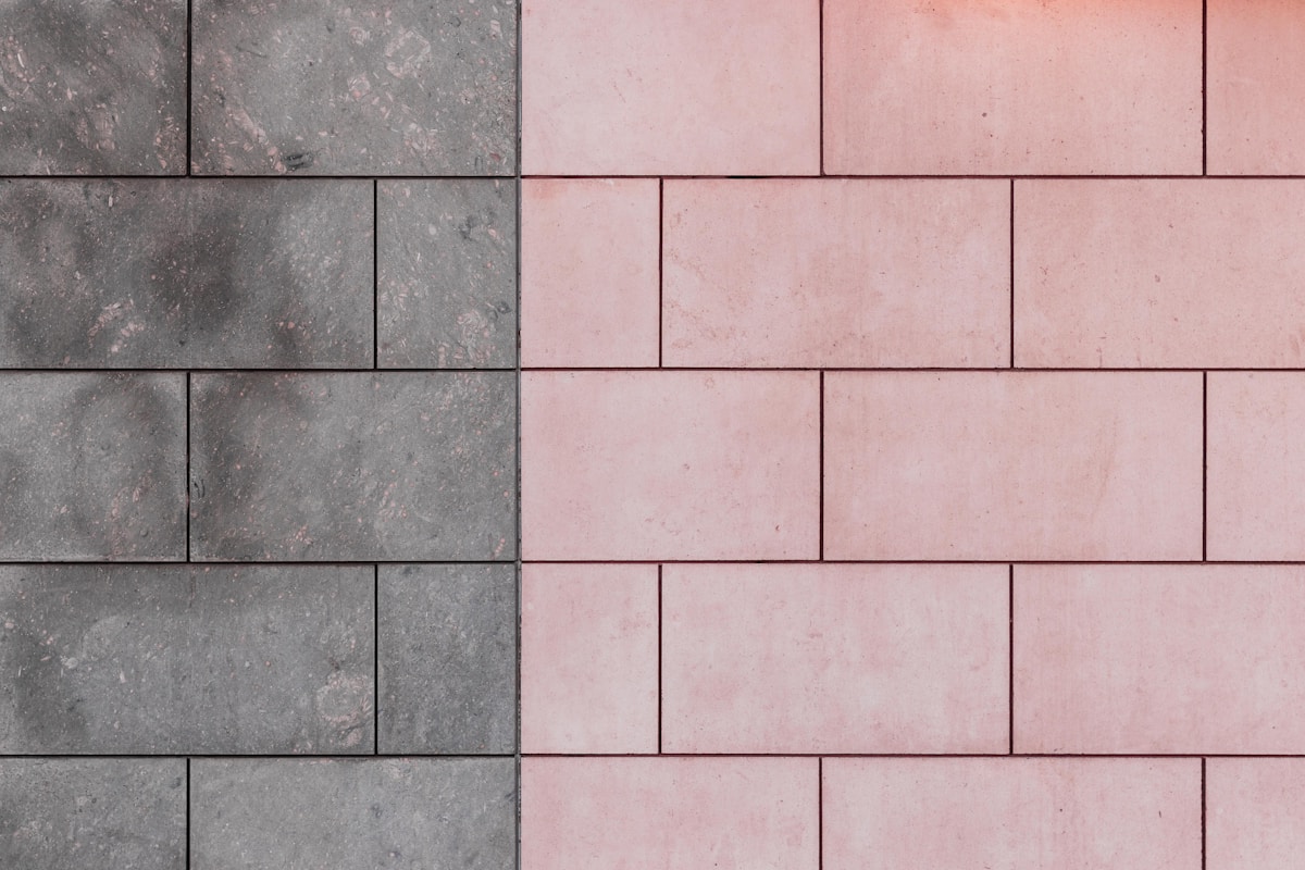 Carreaux de pierre gris et rose disposés en motif géométrique.