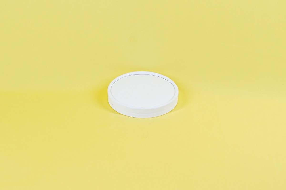 Disque blanc sur fond jaune uni.