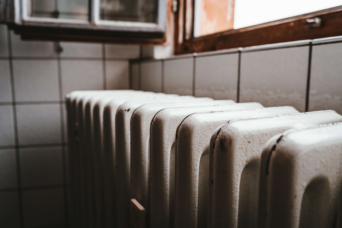 Radiateurs vintage en métal gris dans une pièce sombre.