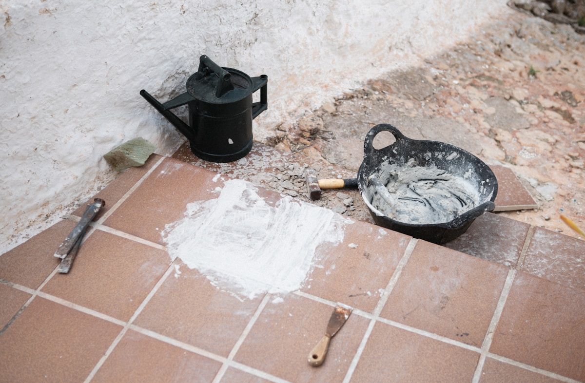 Outils de bricolage et de réparation sur le sol carrelé.