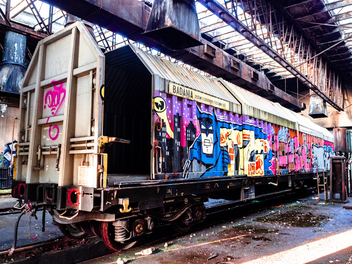 Wagon de train abandonné couvert de graffitis colorés.