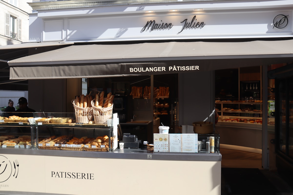 Boulangerie-pâtisserie française avec étalage de pains et viennoiseries.