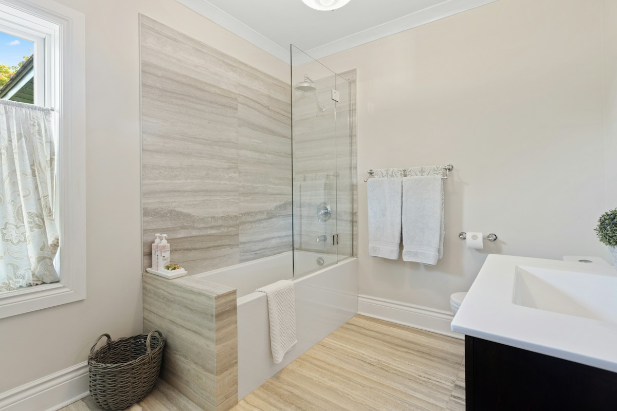 Salle de bains moderne avec baignoire, douche vitrée et meuble vasque.