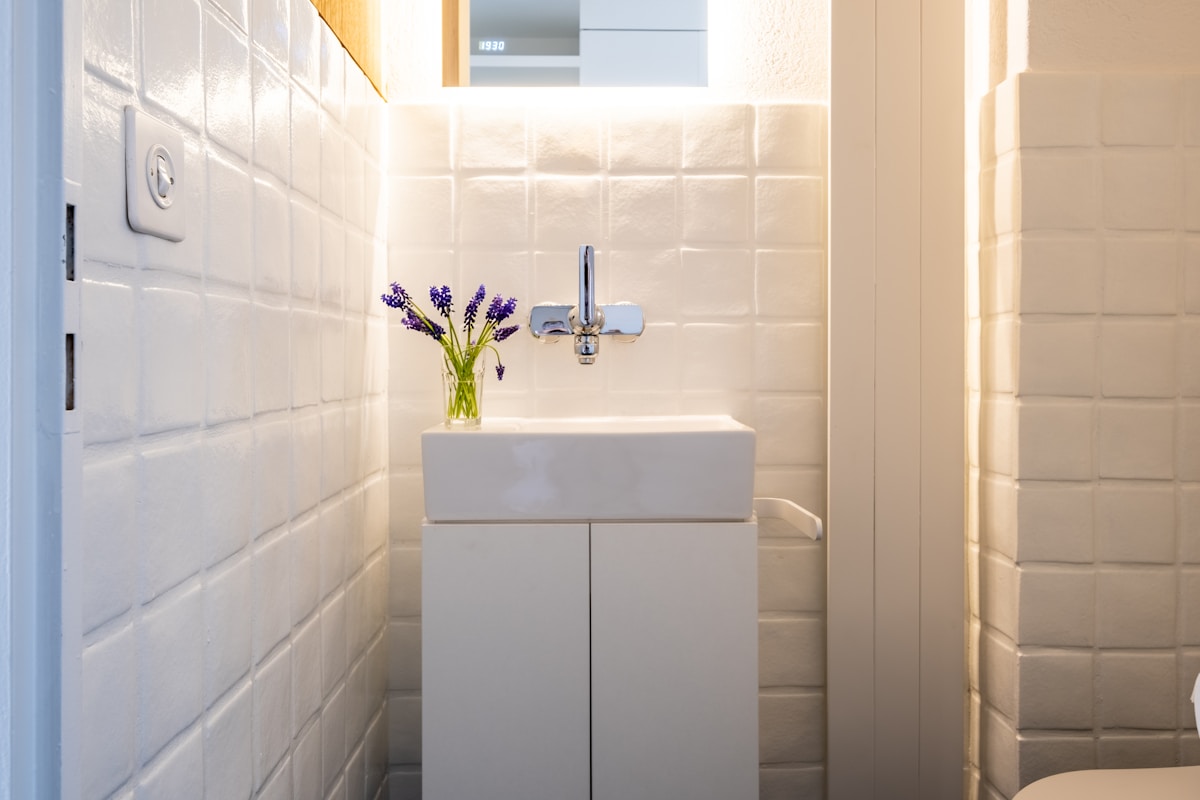 Salle de bain moderne avec lavabo blanc et fleurs de lavande.