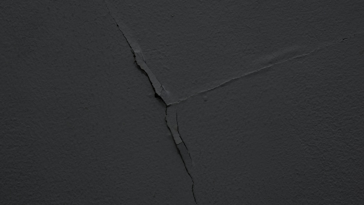Surface de pierre noire fissurée.