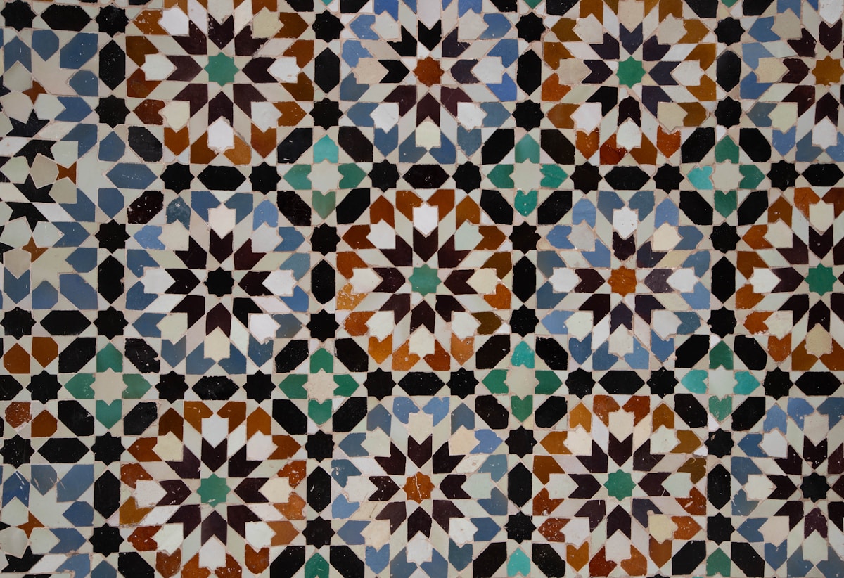 Motifs géométriques colorés et complexes sur carrelage marocain.