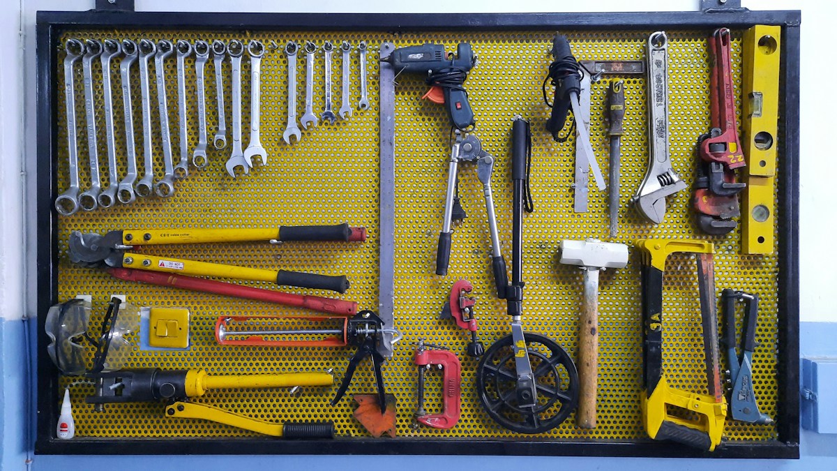 Panneau perforé jaune rempli d’outils de bricolage suspendus